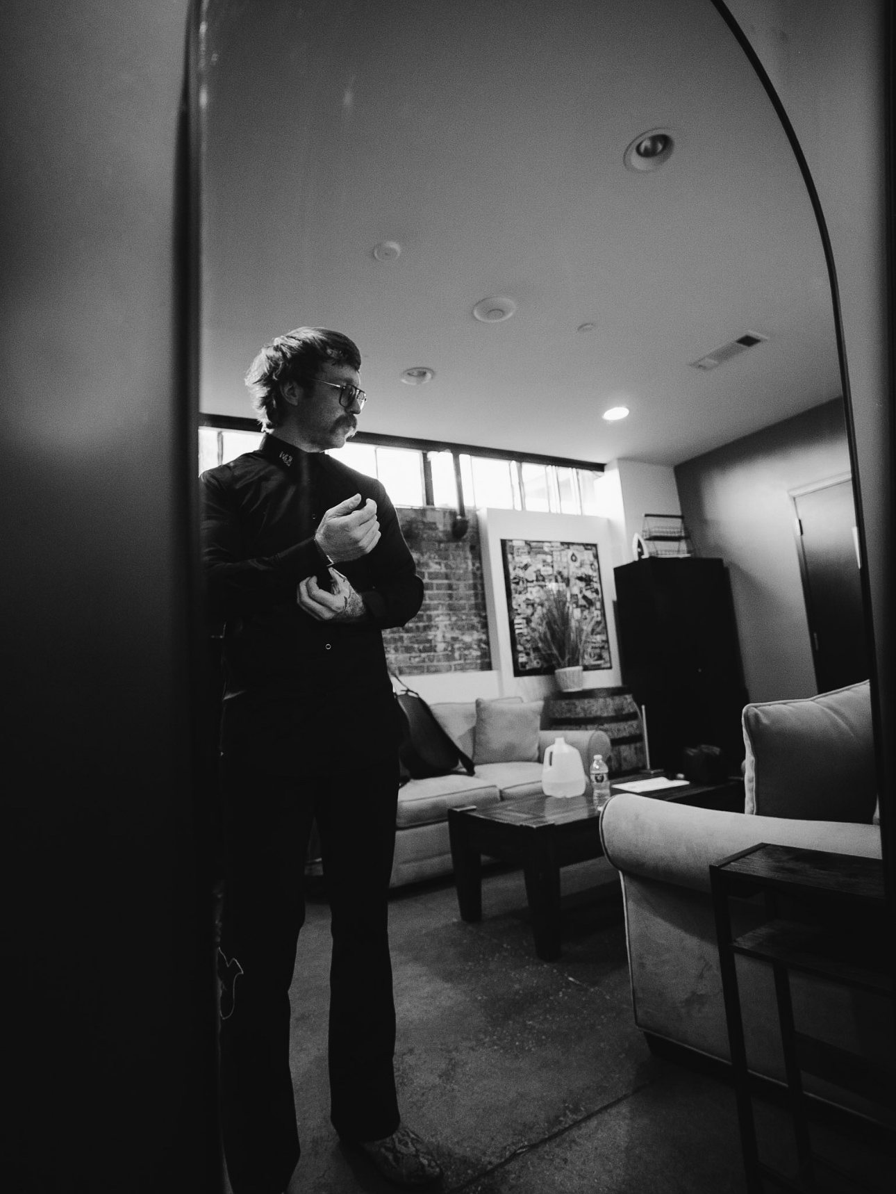 Black and white photo of Trappers Pass adjusting a cuff backstage
