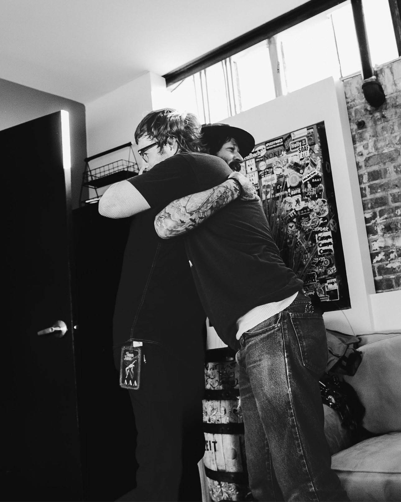 Black and white photo of a backstage hug, with a Shawn James tour pass visible