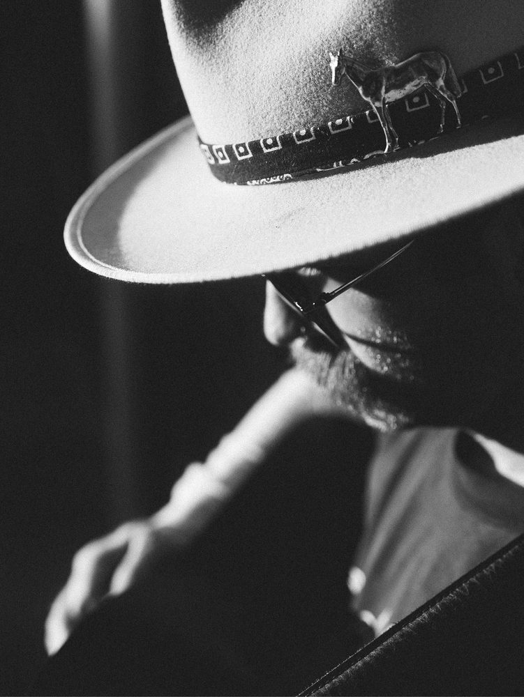 Black and white close-up of Trappers Pass wearing a hat with a horse pin